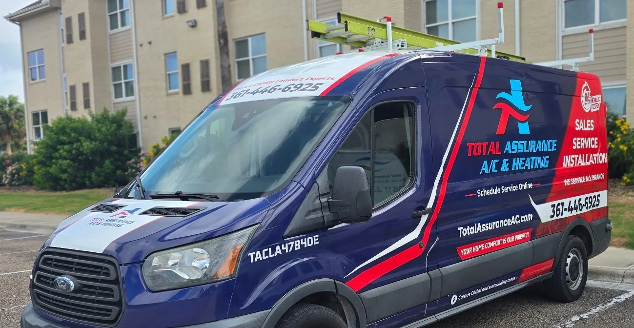 Total Assurance service van with the company wrap, parked outside an apartment building